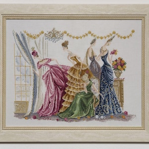 May include: Framed cross-stitch picture featuring five women in period gowns. The dresses are in shades of pink, gold, green, purple, and blue. The image includes a floral arrangement and decorative details. The frame is light-colored wood, giving a vintage feel.