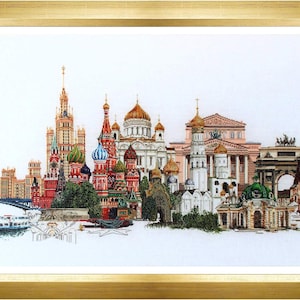 Peut inclure: Une broderie au point de croix encadrée représentant un paysage urbain détaillé de Moscou. L'œuvre présente des monuments emblématiques, notamment la cathédrale Saint-Basile avec ses dômes colorés, le théâtre Bolchoï et diverses tours historiques en rouge, or et blanc.