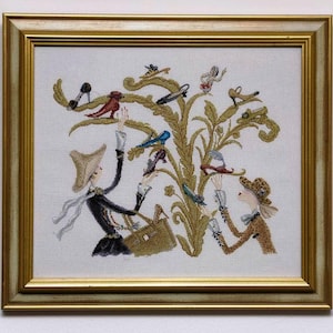 Può includere: Ricamo incorniciato raffigurante una scena stravagante di figure che interagiscono con un albero stilizzato adornato da varie scarpe. L'opera d'arte è ambientata su uno sfondo bianco e incorniciata in una cornice dorata. Le figure sono vestite con abiti d'epoca.