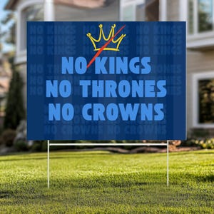 May include: A blue garden sign with white text reading "NO KINGS, NO THRONES, NO CROWNS." A yellow crown with a red line through it is above the text. The sign is displayed on a green lawn.