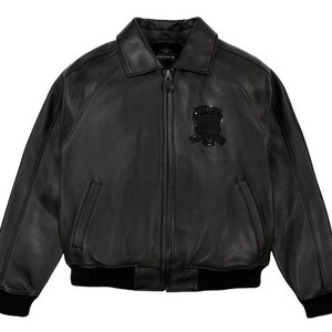 May include: A white ceramic mug with a black handle and the text "But First, Coffee" in a black, bold font. The mug is on a white surface. The mug is approximately 10 cm tall.