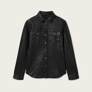 May include: A black leather shirt with a classic collar, two chest pockets, and long sleeves. The shirt has a button-down front and buttoned cuffs. The leather has a slightly textured appearance.