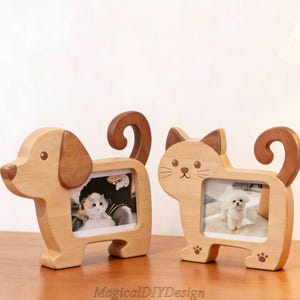 May include: Two wooden photo frames shaped like a dog and a cat. The dog frame is light brown with a darker brown ear and tail. The cat frame has a light brown body with darker brown ears and tail. Each frame holds a small photo.