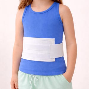 Könnte beinhalten: Ein Kind trägt ein blaues Tanktop und hellgrüne Shorts. Ein weißes Bauchstützband ist um den Oberkörper gewickelt. Das Band hat einen Klettverschluss.