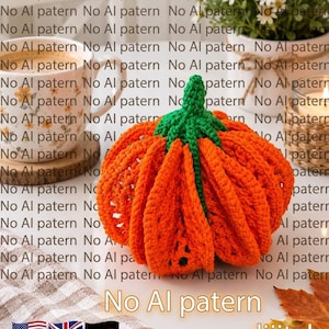 May include: A bright orange crocheted pumpkin with a textured, ribbed surface and a prominent green crocheted stem. The pumpkin is displayed alongside a coffee mug, a potted plant, and a checkered cloth, with the text No Al patern dijital.