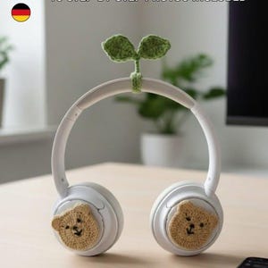 Könnte beinhalten: Weiße Kopfhörer mit braunen, bärenförmigen Häkelakzenten. Ein grüner Häkelspross ist am Kopfband befestigt. Der Text "DIGITAL PATTERN" und "NO-SEW IN 10 MINUTES" ist sichtbar.