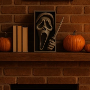 May include: A Halloween-themed display on a brick fireplace mantel. It features a framed Ghostface mask holding a knife, pumpkins, and books. The color palette is warm, with orange and brown tones.