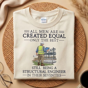 Könnte beinhalten: Cremefarbenes T-Shirt mit dem Text "ALL MEN ARE CREATED EQUAL - ONLY THE BEST - STILL BEING A STRUCTURAL ENGINEER - IN THEIR SEVENTIES." Eine Grafik zeigt einen Bauingenieur auf einer Baustelle.