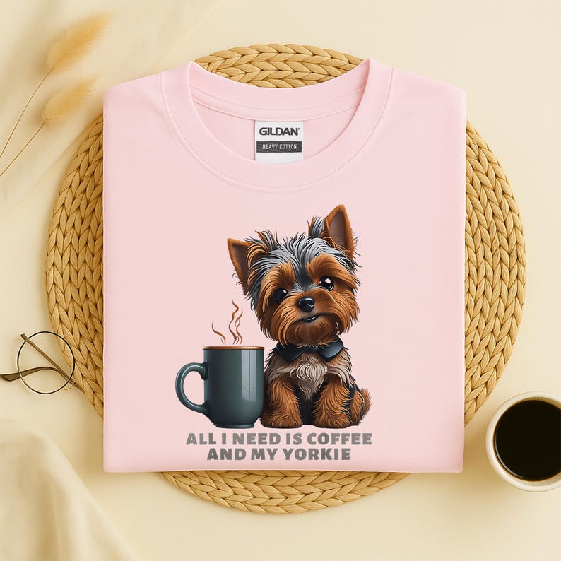 May include: A light pink Gildan heavy cotton sweatshirt featuring a cartoon Yorkshire Terrier next to a dark teal coffee mug. The text "ALL I NEED IS COFFEE AND MY YORKIE" is printed below the mug and dog.