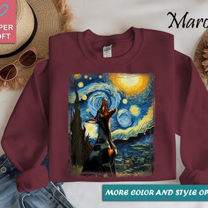 Puede incluir: Sudadera granate con un perro aullando a la luna, inspirada en "La noche estrellada" de Van Gogh. El dise&ntilde;o incluye una luna amarilla, un cielo arremolinado azul y amarillo, y un pueblo. El texto "Super Soft" est&aacute; en la parte superior izquierda.