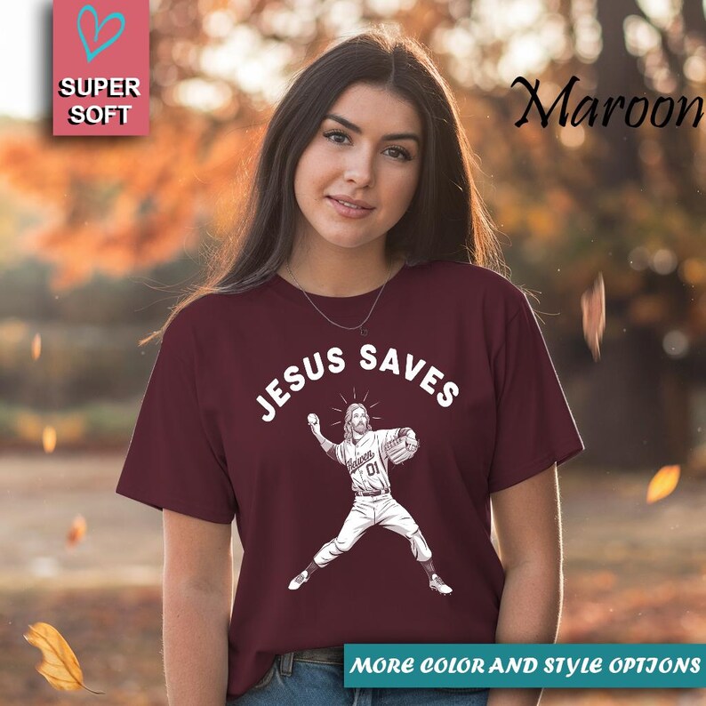 May include: Maroon t-shirt with the text "JESUS SAVES" above an illustration of Jesus as a baseball pitcher. The shirt also has the text "Heaven 01" on the pitcher's uniform. The shirt is labeled "SUPER SOFT".