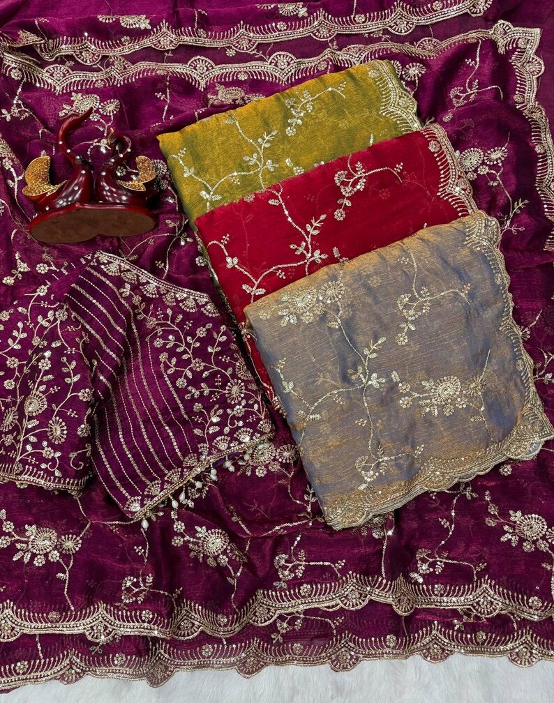 May include: A collection of richly embroidered textiles in shades of purple, red, yellow, and gray. The fabrics feature intricate floral patterns and gold embellishments, suggesting a luxurious aesthetic. The image showcases a variety of textures and designs.