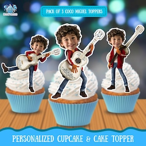 May include: Three cupcakes with white frosting and blue liners, each topped with a Coco Miguel topper playing a guitar. The toppers are in front of a blurred background. Text at the top reads "PACK OF 3 COCO MIGUEL TOPPERS". The bottom text reads "PERSONALIZED CUPCAKE & CAKE TOPPER".
