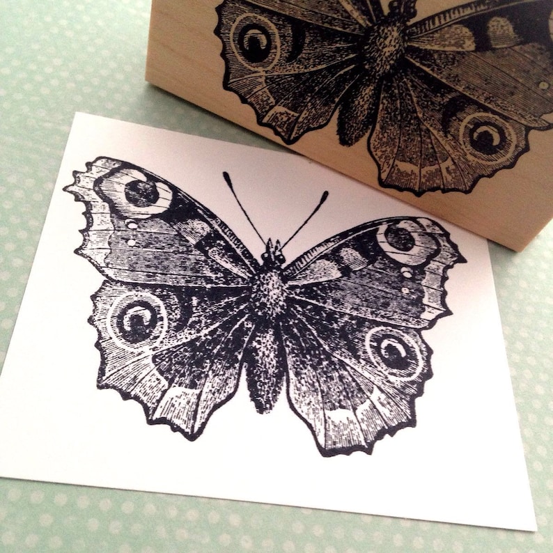 Puede incluir: Ilustraci&oacute;n en blanco y negro de una mariposa con detalles intrincados. La mariposa tiene alas grandes con marcas en forma de ojo.