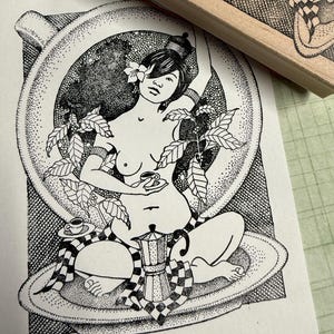 May include: A black and white illustration of a woman sitting in a coffee cup, surrounded by coffee beans and leaves. She is holding a small cup of coffee in her hand. A coffee pot sits in front of her.