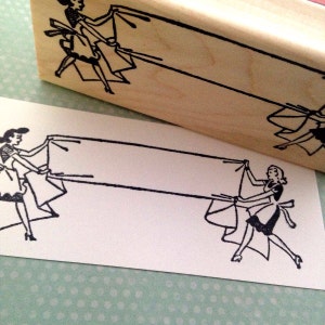 May include: Black and white illustration of two women holding a blank banner. The women are wearing dresses and are in a vintage style.