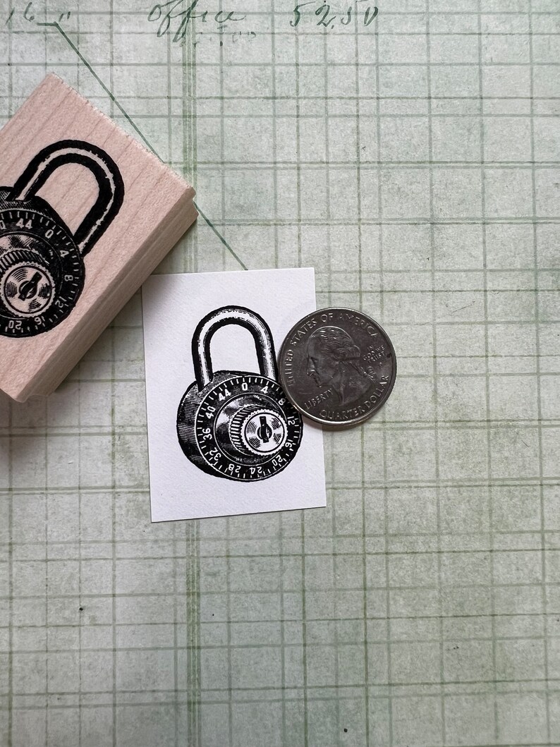May include: A black and white illustration of a combination padlock with the numbers 36 to 44 visible. The padlock is on a white background next to a US quarter.