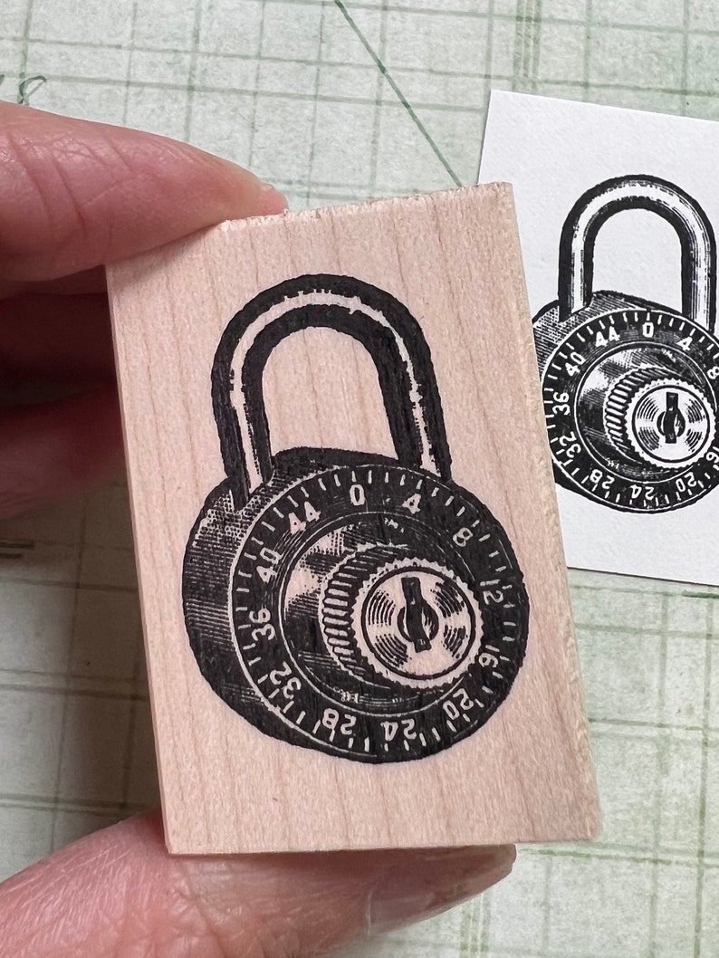 May include: A black and white illustration of a combination padlock with a dial that reads 44, 40, 36, 32, 28, 24, 20, 16, 12, 8, 4, 0.