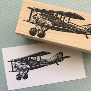 Könnte beinhalten: Ein Holz-Stempel im Vintage-Stil mit einer Schwarzweiß-Illustration eines Doppeldeckers. Der Stempel ist bereit, um ein einzigartiges Design auf Papier zu erstellen.