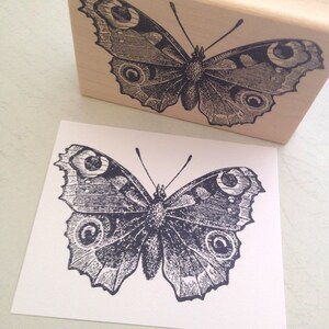 Puede incluir: Una ilustraci&oacute;n en blanco y negro de una mariposa con detalles intrincados. La mariposa tiene alas grandes y redondeadas con un patr&oacute;n de c&iacute;rculos y l&iacute;neas.