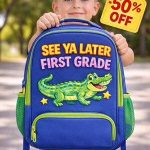 May include: Blue backpack with a green and yellow alligator design, the text "SEE YA LATER FIRST GRADE" and two yellow stars. The backpack has green mesh side pockets and a front pocket. A yellow tag reads "-50% OFF".