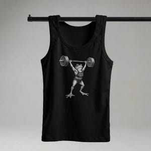 Może przedstawiać: Czarny tank top z grafiką żaby podnoszącej ciężary. Żaba podnosi sztangę. Grafika zawiera napis "TOAD STRENGTH CLUB". Projekt jest monochromatyczny.