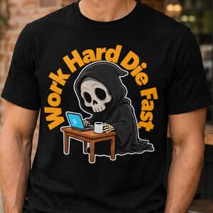 Peut inclure: Un t-shirt noir avec un motif de faucheuse en dessin animé portant une robe à capuche noire, assise à un bureau en bois marron avec un ordinateur portable bleu clair et une tasse à café blanche. Le texte Work Hard Die Fast est en jaune.