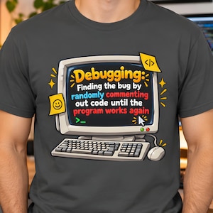 Op de afbeelding: Een antracietgrijs t-shirt met een afbeelding van een vintage computermonitor en toetsenbord. Op het scherm staat de tekst: Debugging: Finding the bug by randomly commenting out code until the program works again, met een cursor en code-iconen.