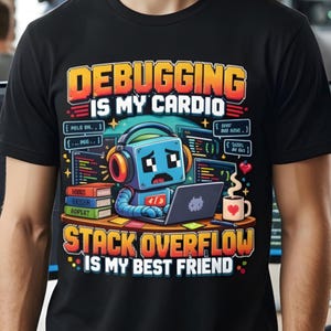 Może przedstawiać: Czarny t-shirt z grafiką niebieskiego robota w słuchawkach, piszącego na laptopie. Tekst głosi: DEBUGGING IS MY CARDIO oraz STACK OVERFLOW IS MY BEST FRIEND. Wzór zawiera stosy książek, fragmenty kodu oraz kubek z kawą.