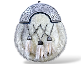 Könnte beinhalten: Eine traditionelle schottische Sporran mit einem silberfarbenen Cantle mit keltischen Knoten. Der Fellbeutel ist hellgrau und cremefarben, mit drei dekorativen Quasten, die an Ketten hängen. Ein klassisches Accessoire.