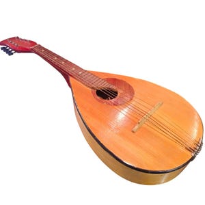 Puede incluir: Mandolina de madera con cuerpo marrón claro y clavijero rojo. El instrumento tiene una boca redonda y seis cuerdas. La mandolina es un instrumento musical de cuerda.