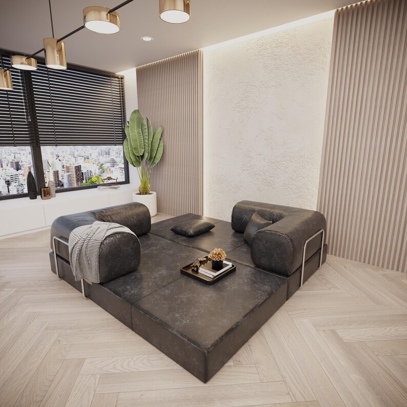 Puede incluir: Un sal&oacute;n moderno con un sof&aacute; modular de cuero negro. El sof&aacute; est&aacute; dispuesto en forma cuadrada, con un peque&ntilde;o otom&aacute;n cuadrado y una bandeja decorativa con flores. La habitaci&oacute;n tiene grandes ventanales y una planta.