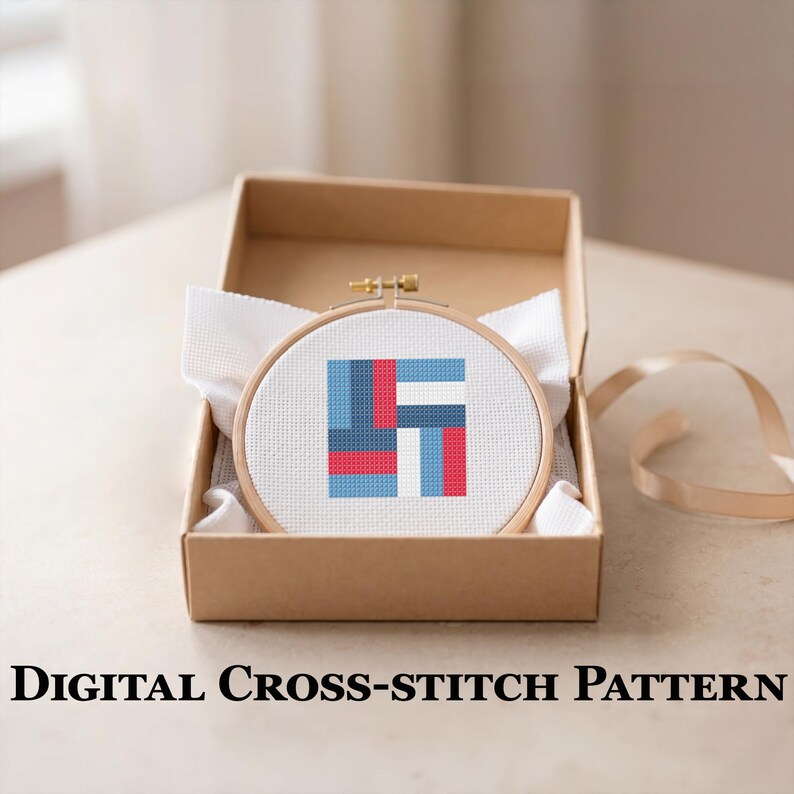 May include: A cross-stitch pattern in a wooden hoop, featuring a geometric design in red, blue, and white, is presented in a brown cardboard box. The text "DIGITAL CROSS-STITCH PATTERN" is displayed below the box.