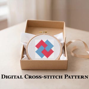 May include: A cross-stitch pattern in a wooden hoop, featuring a geometric design of interlocking red and blue squares on a white background. The hoop is presented in a brown cardboard box with white fabric. The text "DIGITAL CROSS-STITCH PATTERN" is at the bottom.