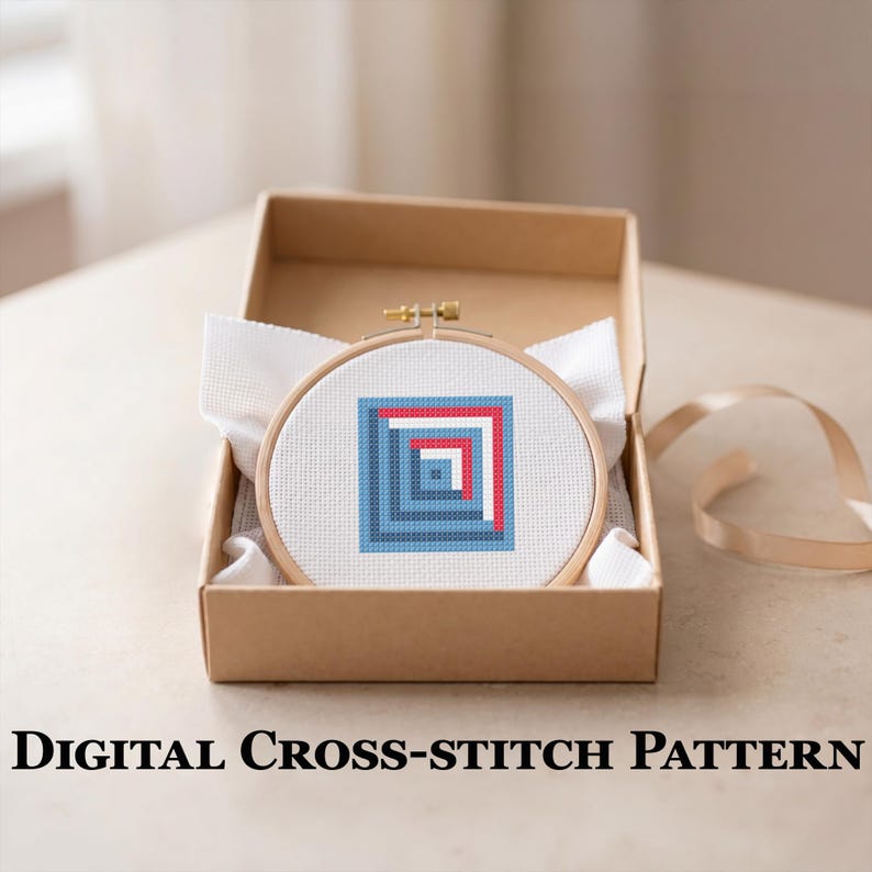 May include: A cross-stitch pattern in a wooden hoop, featuring a geometric design of blue and red squares, is presented in a brown cardboard box. The text "DIGITAL CROSS-STITCH PATTERN" is displayed below the box. A white fabric and a ribbon are also visible.