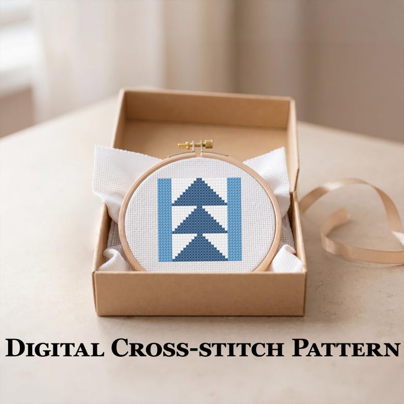Peut inclure: Un motif de point de croix dans un cercle en bois, avec un motif g&eacute;om&eacute;trique de triangles bleus et de barres verticales, pr&eacute;sent&eacute; dans une bo&icirc;te en carton avec du tissu blanc. Le texte "DIGITAL CROSS-STITCH PATTERN" est en bas.