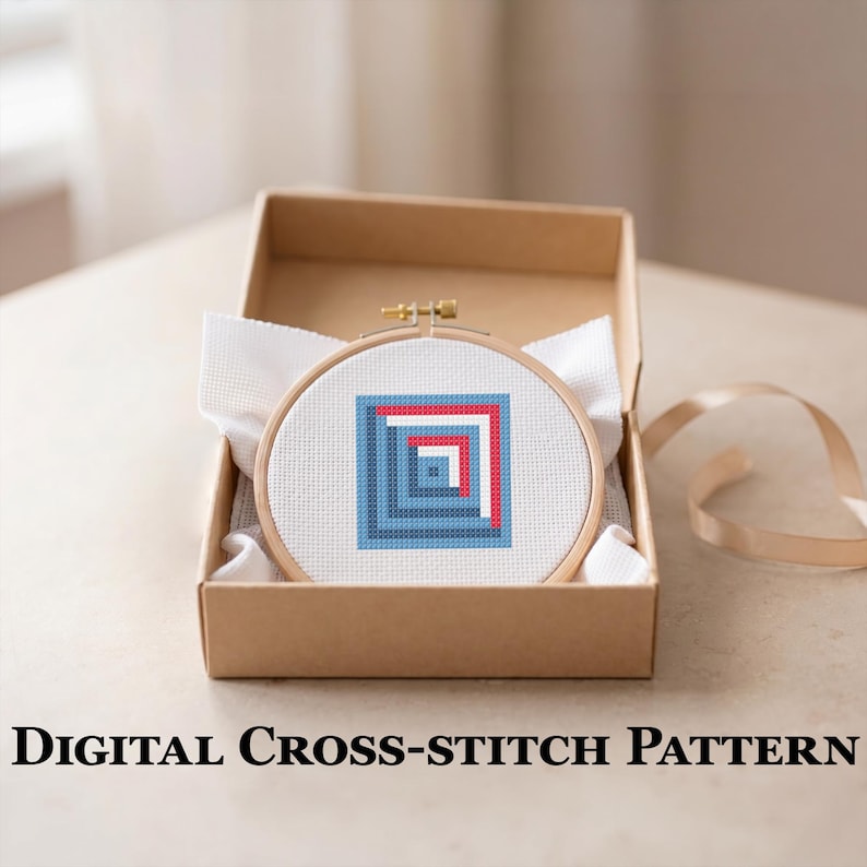 May include: A cross-stitch design in a wooden hoop, with a geometric pattern of blue and red squares, is displayed in a brown cardboard box. The text "DIGITAL CROSS-STITCH PATTERN" is below the box. White fabric and a ribbon are also visible.