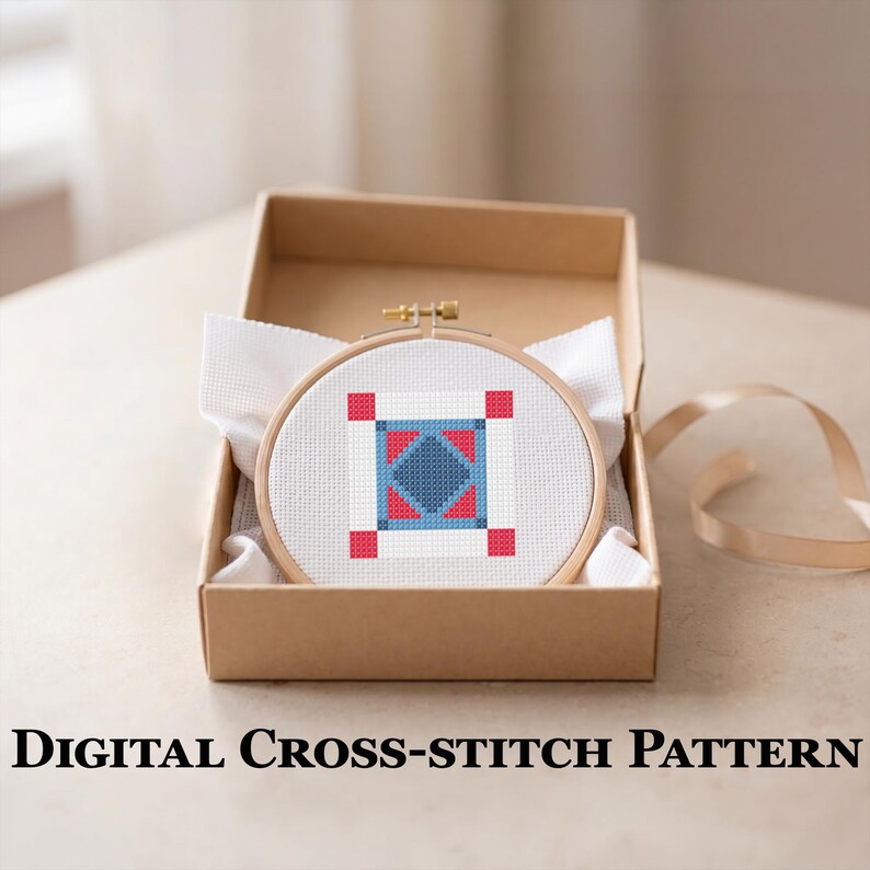 May include: A cross-stitch pattern in a wooden hoop, featuring a geometric design in red, blue, and white, is presented in a brown cardboard box. The text "DIGITAL CROSS-STITCH PATTERN" is displayed below the box.