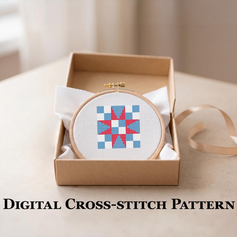May include: A cross-stitch design in a wooden hoop, with a geometric pattern of red, white, and blue squares and a star. The hoop is displayed in a brown cardboard box with white fabric. The text "DIGITAL CROSS-STITCH PATTERN" is at the bottom.