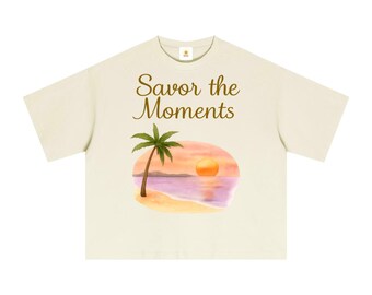 Essential Sorona boxy t‑shirt with beach style, palm trees, sunset colors, peaceful ocean vibe, and a soft tropical coastal feel.