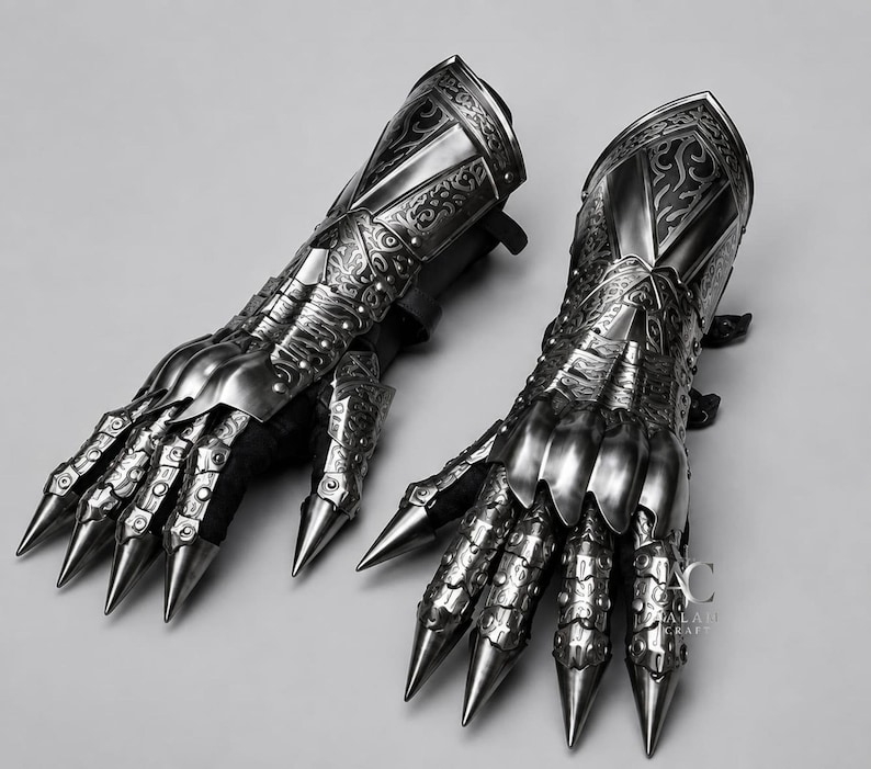 Puede incluir: Un par de guanteletes de metal articulado con intrincados patrones de volutas grabados, placas de dedos puntiagudas y un acabado plateado pulido. Las piezas de armadura incluyen un protector de antebrazo y el logo AC ALAH CRAFT a la derecha.