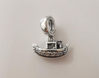 May include: A silver charm with a gondola design. The gondola has a row of clear stones along the front and a small figure of a gondolier. The charm has the word "Pandora" and "ALE" engraved on it.