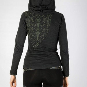 May include: Black long-sleeved shirt with a green patterned design on the back. The shirt has a hood and a black belt.