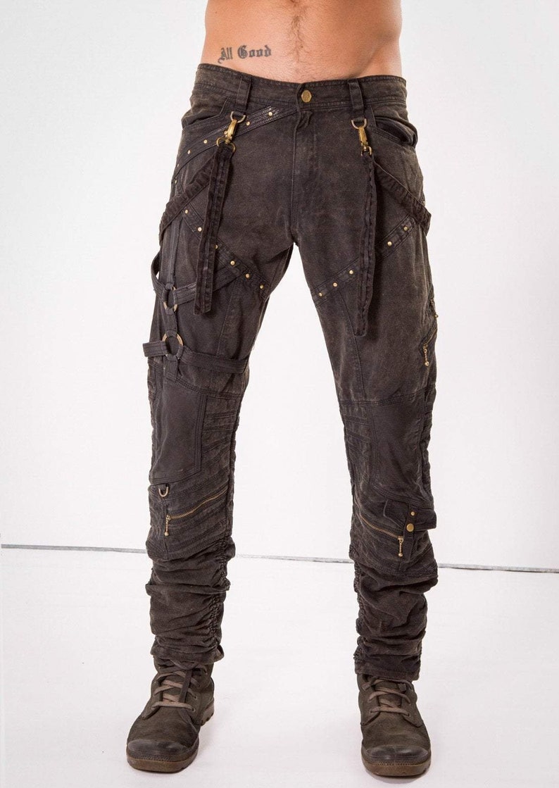 May include: Dark brown cargo pants with multiple straps and buckles, accented with gold hardware and studs. The pants have a distressed look and are designed for a casual, edgy style.