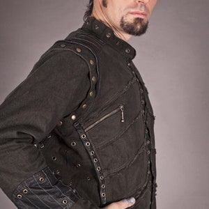 May include: A black denim jacket with multiple layers and decorative stitching. The jacket has a zip closure and is adorned with metal studs and eyelets.