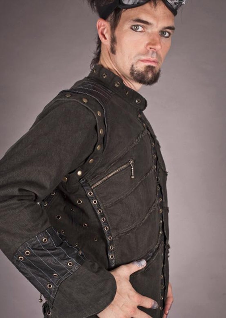 May include: A black denim jacket with multiple layers and decorative stitching. The jacket has a zip closure and is adorned with metal studs and eyelets.