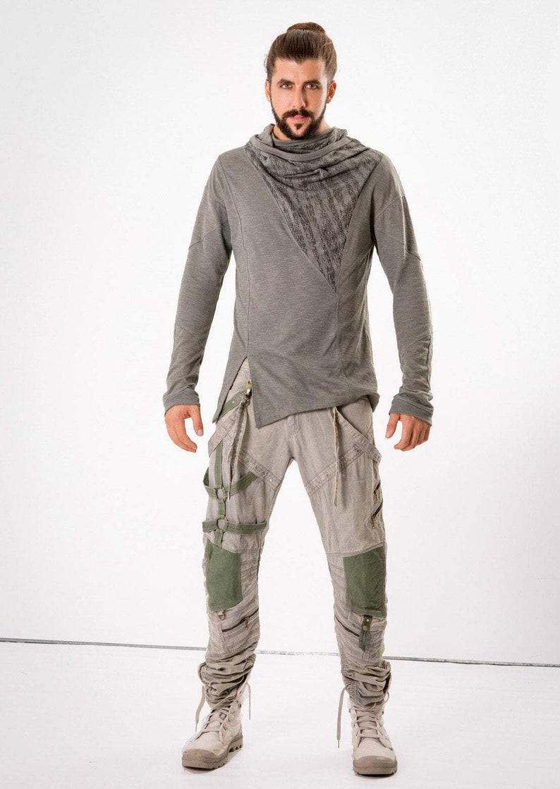 May include: A gray long-sleeved shirt with a cowl neck and a gray and green pair of pants with a unique design featuring straps and buckles.