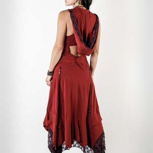 May include: A red sleeveless dress with a hood and a lace trim. The dress has a cut-out back and a flowing skirt.