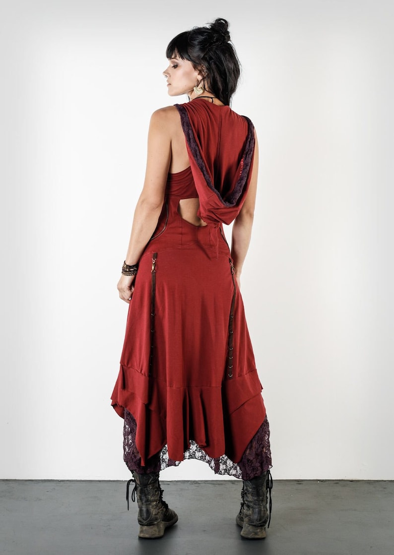 May include: A red sleeveless dress with a hood and a lace trim. The dress has a cut-out back and a flowing skirt.