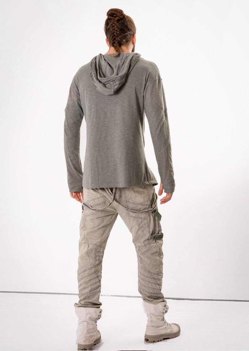 May include: A gray long-sleeved hooded shirt with a relaxed fit and a pair of gray cargo pants with multiple pockets and straps.